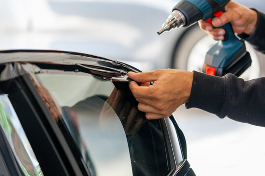 A car wrapping specialist applies a polyurethane film to the car. Detailer PPF