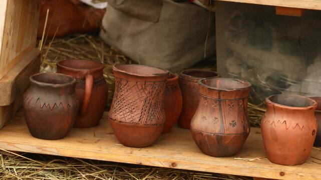 A collection of vases on a wooden shelf, great for decorative or commercial use