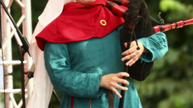 Man in medieval costume holding bagpipes, perfect for historical or cultural themes
