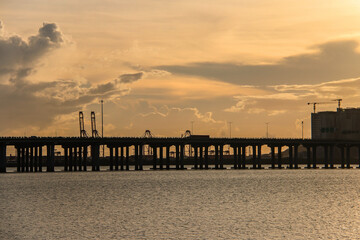 Obraz premium Bridge Silhouette Over Water at Sunset