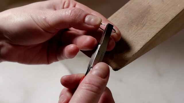 Nail cutting close up of cropped hands trimming fingernails with clipper for hygiene routine in 4K Ultra HD footage.
