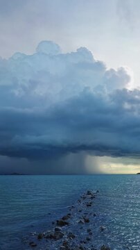 Vertical video. Slow Motion Ultra Wide Angle View of a Massive Tropical Storm Over the Sea, Heavy Rainfall, Dark Clouds, Coastal Landscape, Extreme Weather and Natural Power