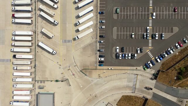 Top down aerial view of parked cars and HGV lorries lined up at logistics distribution centre Luton UK
