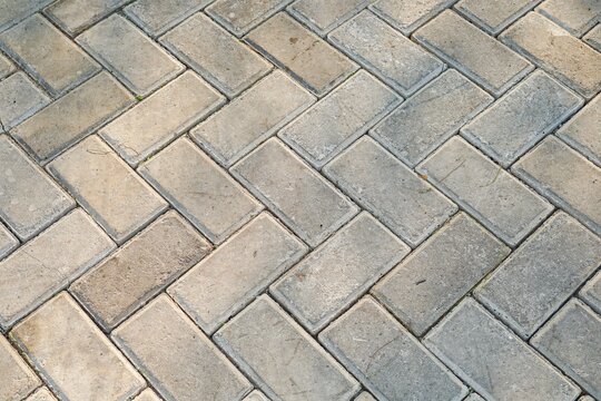 Herringbone pattern concrete paving blocks outdoor sidewalk texture with sun light