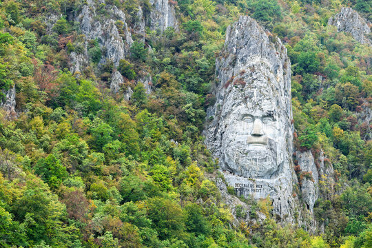 Stone carved sculpture of Decebalus in the Iron Gates area of Serbia among lush greenery