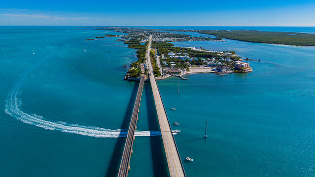 View of 7 mile bridge connecting islands in the Florida Keys with clear waters and boats in the distance