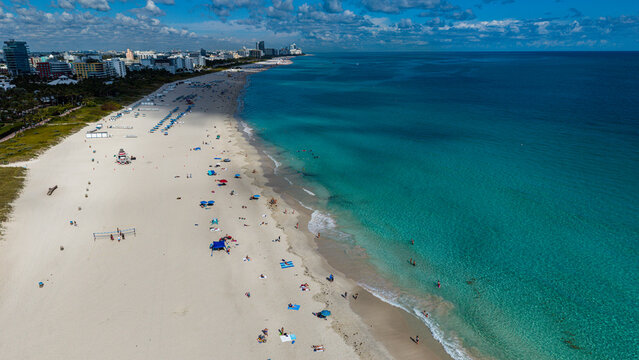 Vibrant beach scene with people and umbrellas at South Beach point in Miami, Florida during daytime