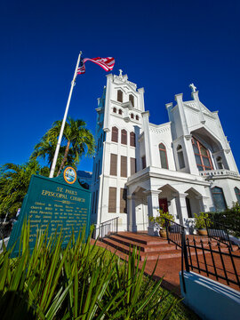 St. Peters Episcopal Church stands in bright sunlight against a clear blue sky in Florida