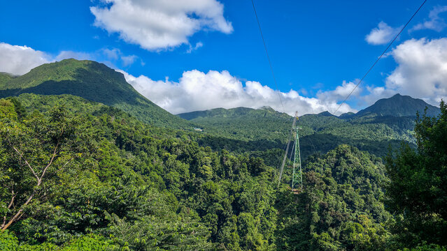 Morne Trois Pitons National Park features green mountains and blue skies with cables connecting peaks in Dominica