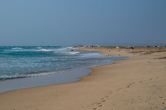 Scenic sandy beach with gentle waves and distant shoreline in Puntland, Somalia during daylight