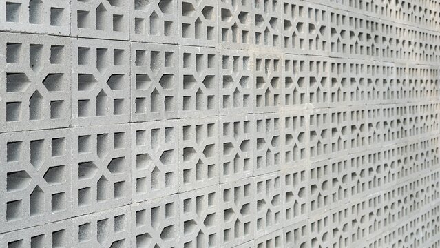 Perforated breeze block cement wall with geometric star pattern in perspective view