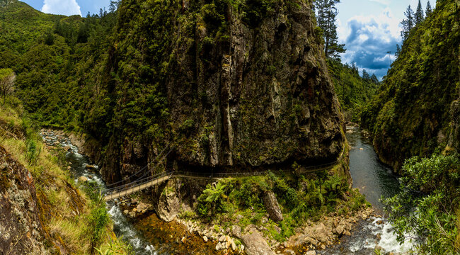 Scenic views along the Karangahake Gorge hike with a river and bridge surrounded by rocks and greenery in North Island New Zealand