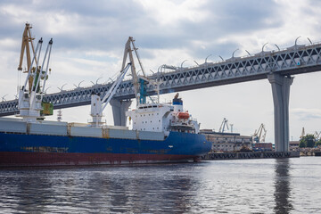 Naklejka premium A large cargo ship on the sea channel on Kanonersky Island. Transportation of various goods and products on cargo ships