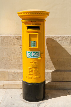 Vintage British-era post box with E II R cypher in use on a sunlit street in Cyprus