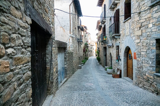 Narrow medieval street with traditional stone houses in A&iacute;nsa, Huesca, Spain