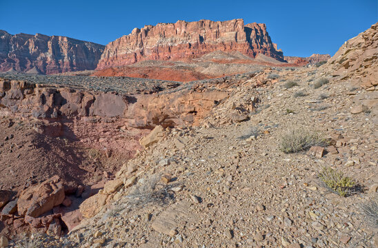 Cliffs rise sharply at Soap Creek Mesa with layers of red rock under clear skies in Arizona national monument setting
