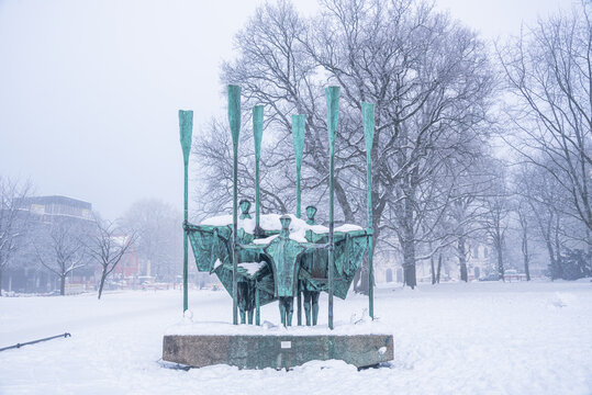 Bronze figures of Die Auswanderer monument in snowfall represent emigrants leaving Europe for new lives