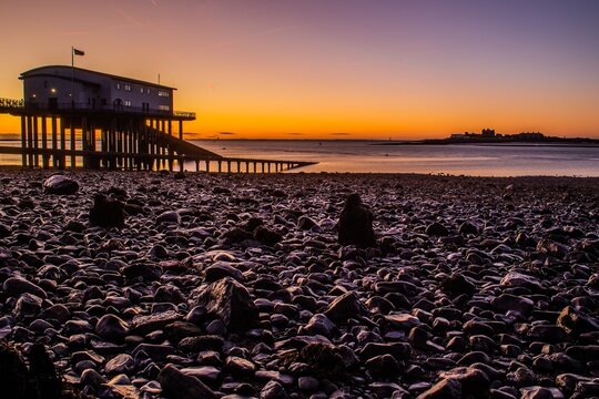 Sunrise over Roa Island Lifeboat Station with rocky shore on the Cumbrian Coast