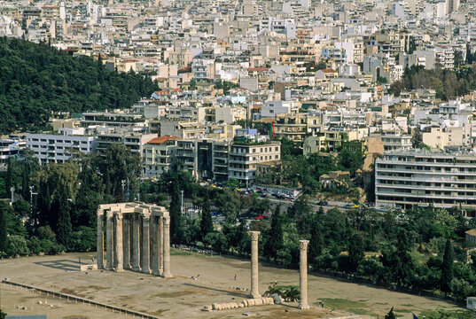 View of Temple of Olympian Zeus from Acropolis with city buildings in the background in Athens, Greece