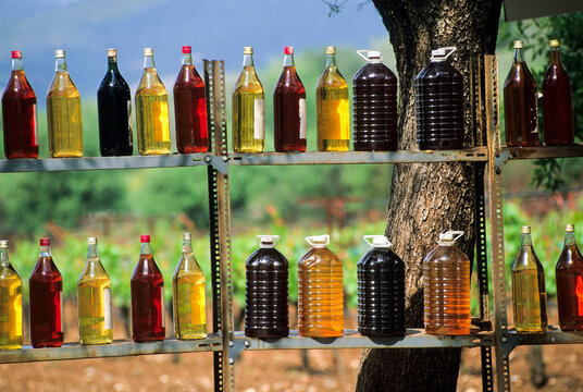 Bottles of wine for sale by the roadside in Argos with wooden shelves and a scenic backdrop