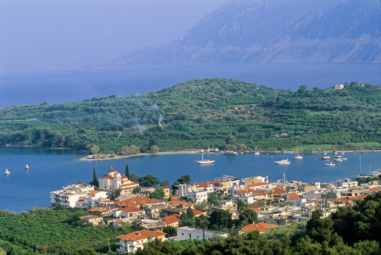 View of Palaia Epidavros with boats in the harbor and hills in the background during daylight