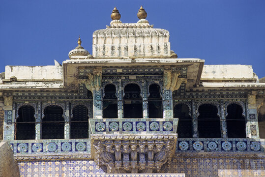 Historic architecture of City Palace in Udaipur features intricate detailed work and vibrant colors under clear skies