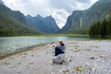 Fototapeta premium Man contemplating Dolomites lake view in Alps