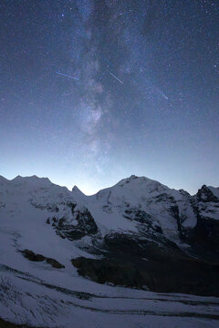 Snowcapped Piz Palu and Piz Bernina under the starry night sky, Engadin, Graubunden, Switzerland