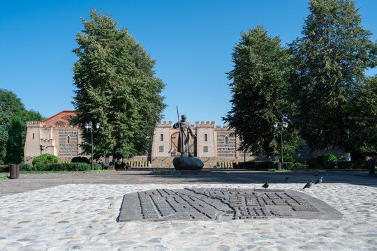 VLADIKAVKAZ, RUSSIA - AUGUST 21: A bronze relief map model of the historical city on a stone square against the monument to Dzaug Bugulov and a brick fortress wall.