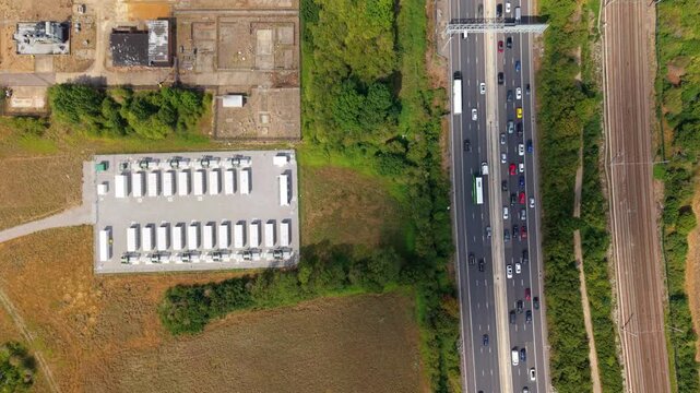 Top down aerial view of busy M1 motorway traffic and battery energy storage system in Luton UK