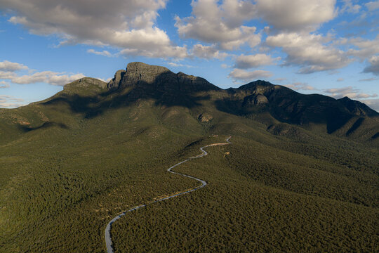 Aerial view of a winding road leading towards the rugged mountain peaks of Stirling Range National Park, Western Australia, Australia.