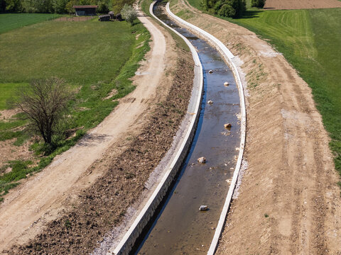 River channel expansion and flood protection work in a rural area. The reinforced waterways and raised embankments enhance flood management.