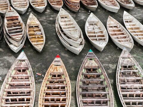 Aerial view of many traditional wooden boats lined up on the ground in Ghior Upazila, Manikganj, Dhaka Division, Bangladesh.