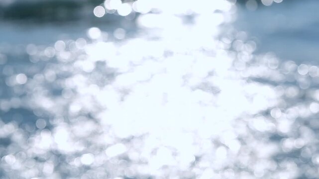 Sea. Sea waves. Abstract view of blue sea with white ripples on water and white sun glare on sunny summer day. Nature backdrop. Natural background. Blurred bokeh background.