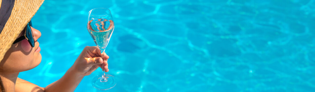 Women with champagne in the pool. Selective focus.