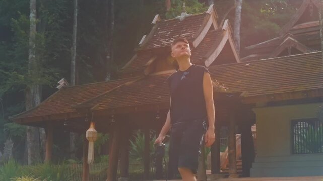 man traveler with camera at ancient Buddhist temple in Chiang Mai, Tourist visiting historic pagoda surrounded by forest at Thai cultural landmark Wat Phra Lat 4k