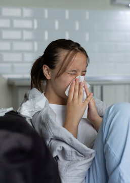 Sick girl with runny cold symptoms resting at home, representing illness, flu and seasonal infection