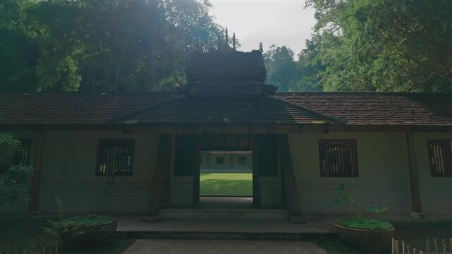 Entrance to Wat Phra Lat Buddhist temple by tropical forest in Chiang Mai Thailand, Traditional monastery architecture with peaceful garden courtyard and lush greenery at sunset 4k