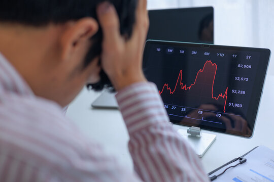 Stressed Investor Looking at Market Crash Stock Chart on Tablet in Office.