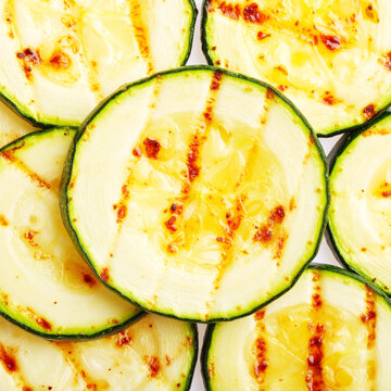 Grilled zucchini slices, top view, white backdrop closeup. AI