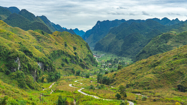 Winding road through dramatic mountain valley on Ha Giang Loop, Vietnam