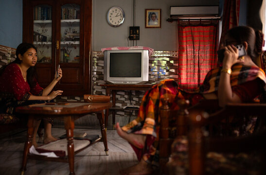 Mother and daughter sit inside home