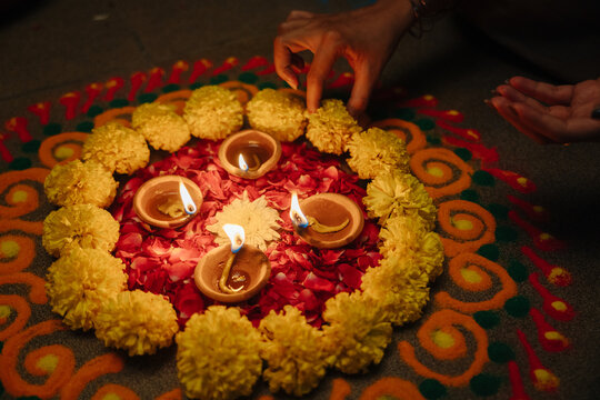 Creating Rangoli With Flowers and Oil Lamps for Festival Celebration