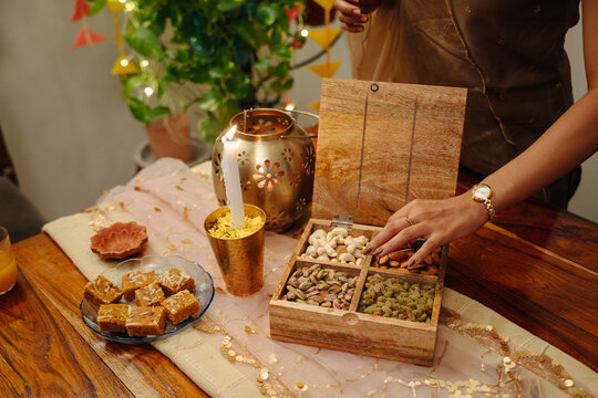 Person Enjoying Snacks and Games During a Gathering at Home
