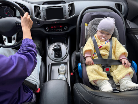 Driver and baby travel in a car on a city street