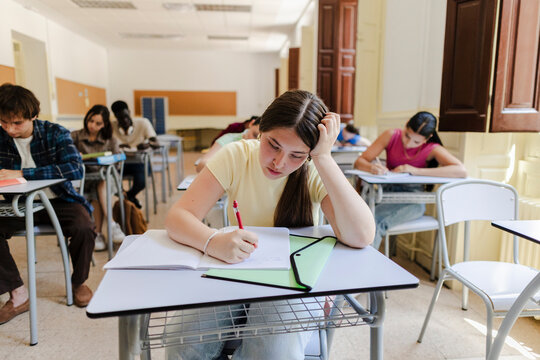 Female student concentrating on test in a bright classroom