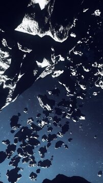 dark asteroid field drifting past ice, cinematic closeup of jagged icy rocks tumbling through starfilled deep blue void, survey probe pinging telemetry,