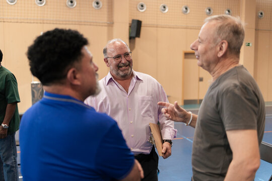 Group of men communicating and collaborating in a sports hall