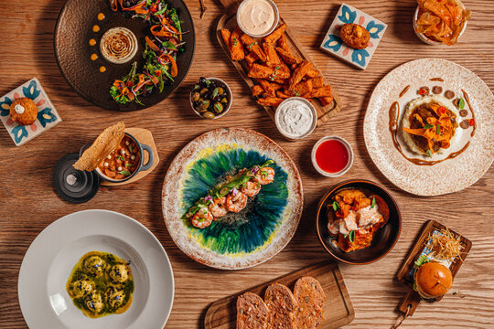 Wooden table filled with an assortment of gourmet Spanish tapas