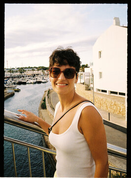 Person enjoying summer vacation smiling at coastal marina